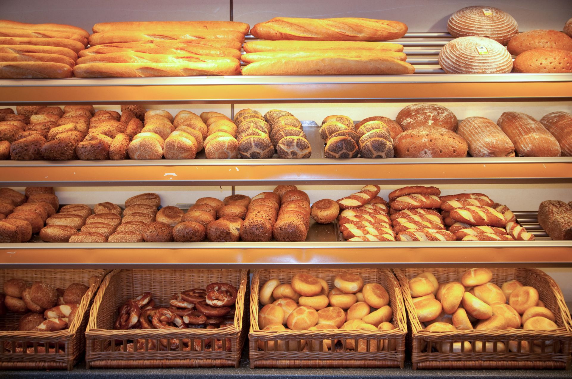 Verschiedene Brote, Brötchen und Gebäck auf Regalen in der Bäckerei